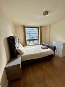 - une chambre avec un lit, une chaise et une fenêtre dans l'établissement Holliday Street Apartments - One Bedroom - Stunning Balcony, à Birmingham