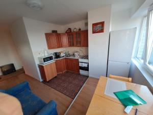 una pequeña cocina con armarios de madera y nevera blanca. en Hero Avenue Apartment en Narva