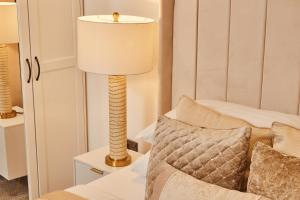 a lamp sitting next to a bed in a room at Modern Leeds Dock Apt &Free Secure Parking! in Leeds