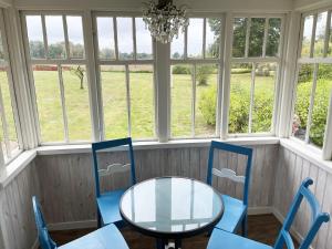 a table and chairs in a room with windows at Nice cottage located close to a bay in Skappevik in Bergkvara