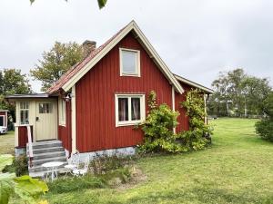 a red house with a bench in front of it at Nice cottage located close to a bay in Skappevik in Bergkvara