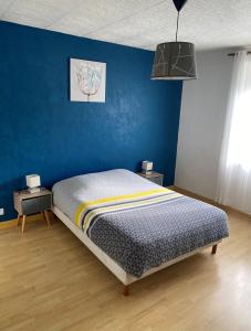 um quarto com uma cama com uma parede azul em Gite Les Marmottes em La Salle