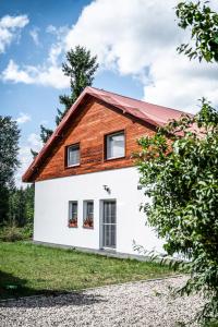 een wit huis met een rood dak bij Bezkresne- Domy w Sidorach in Jeleniewo