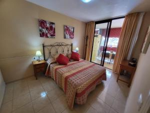 um quarto com uma cama com almofadas vermelhas em Olivia Sunset 2 em Puerto de Santiago