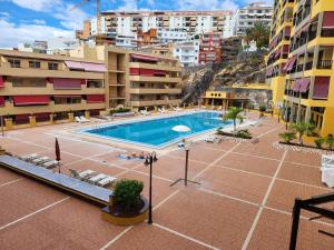 uma piscina exterior numa cidade com edifícios em Olivia Sunset 2 em Puerto de Santiago