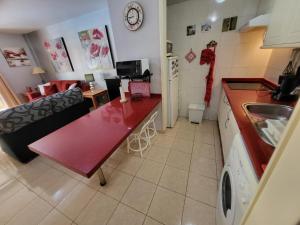 uma cozinha com um balcão vermelho num quarto em Olivia Sunset 2 em Puerto de Santiago