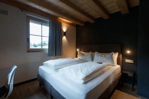 a bedroom with a large white bed with a window at Sun Villa Genf with Spa in Livigno