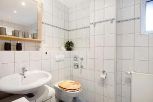 a white bathroom with a toilet and a sink at Kirsten's Hike n Bike Ferienwohnung in Schmallenberg