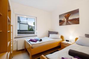 een slaapkamer met 2 bedden en een raam bij Kirsten's Hike n Bike Ferienwohnung in Schmallenberg