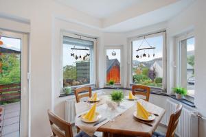 uma sala de jantar com uma mesa e algumas janelas em Kirsten's Hike n Bike Ferienwohnung em Schmallenberg
