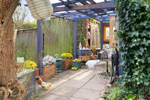 un jardín con pérgola azul y algunas plantas en tinyhouse-gem-kleinodye, 