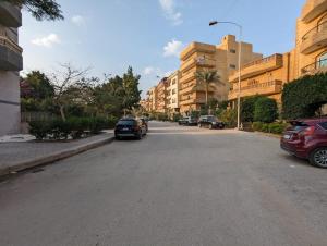 une rue avec des voitures garées sur le côté de la route dans l'établissement Charming Apartment in 6th October Cairo Giza Family Only, à Ville du 6 Octobre
