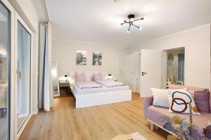 Un dormitorio blanco con una cama y un sofá. en Ferienwohnung Bergwiese, en Schmallenberg