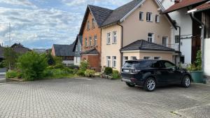 a black car parked in front of a house at Charmante Bauernhofwohnung in Lautertal in Lautertal