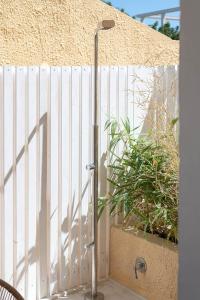 a white fence with a pole next to a plant at Le Palmette Suites in Cagliari