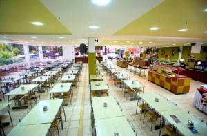ein Restaurant mit Tischen und Stühlen in der Unterkunft Golden Dolphin Grand Hotel - Caldas Novas in Caldas Novas + 28 Fotos
