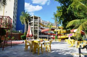 eine Gruppe von Tischen und Stühlen mit einem Wasserpark in der Unterkunft Golden Dolphin Grand Hotel - Caldas Novas in Caldas Novas
