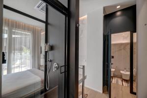 a bedroom with a door leading to a bathroom at Le Palmette Suites in Cagliari