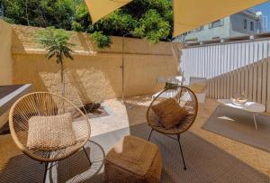 a patio with two chairs and an umbrella at Le Palmette Suites in Cagliari