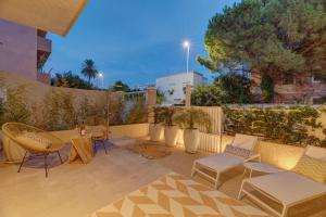 a patio with chairs and tables and a fence at Le Palmette Suites in Cagliari