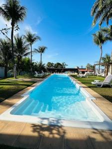 a large blue swimming pool with palm trees in the background at Villa Simone in Natal