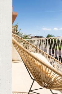 a wicker bench sitting on a balcony at Le Palmette Suites in Cagliari
