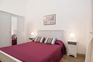 een slaapkamer met een paars bed en 2 nachtkastjes bij Casa vacanze Cristina in Noto