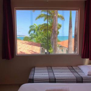 a bedroom with a window with a view of the ocean at Villa Simone in Natal