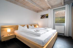um quarto com uma grande cama branca e uma janela em Ferienhaus Unter den Eichen em Röbel