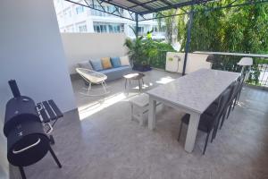 een patio met een tafel en stoelen en een bank bij Neverland Hua Hin - Beach Retreat Home in Hua Hin
