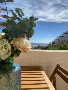 eine Vase mit Blumen auf einem Tisch auf einem Balkon in der Unterkunft SOFIA PLAYA LAS VENTANICAS in Mojácar