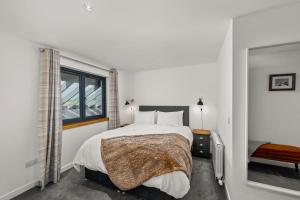 um quarto branco com uma cama e uma janela em Wester Den em Arbroath