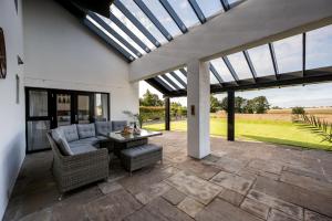 a patio with a couch and a table and windows at Wester Den in Arbroath