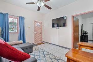 a living room with a couch and a tv at Shaw Park Gem Apt 12D in Ocho Rios