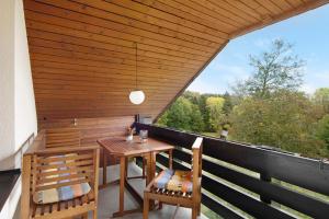 patio con mesa y sillas en el balcón en Landhaus Am Schmiedebach, en Wittenschwand