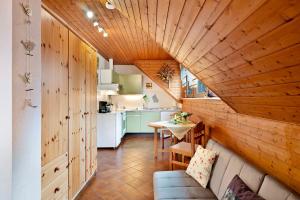 sala de estar con techo de madera y cocina en Landhaus Am Schmiedebach, en Wittenschwand