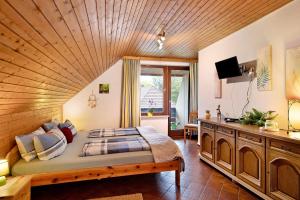a bedroom with a large bed with a wooden ceiling at Landhaus Am Schmiedebach in Wittenschwand