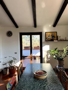 una sala da pranzo con tavolo e sedie e una stanza con finestra di Apartment in Villa La Carruba a Rivergaro