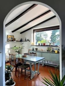 リヴェルガーロにあるApartment in Villa La Carrubaのキッチン(テーブル、椅子付)