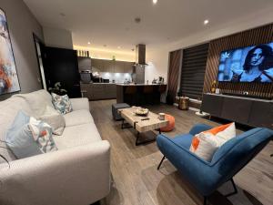 Il comprend un salon avec un canapé et des chaises ainsi qu'une cuisine. dans l'établissement Staines Home Stay, à Staines upon Thames