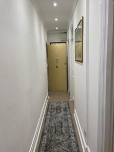 a hallway with a yellow door and a rug at The South Kensington Apartments in London
