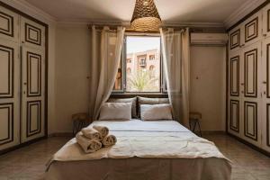 a bedroom with a large bed with towels on it at Central Majorelle Apartment in Marrakech