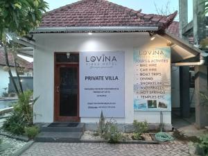 a small white building with a sign on it at Lovina Vibes Hotel in Balian