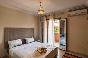 a bedroom with a large bed with towels on it at Central Majorelle Apartment in Marrakech