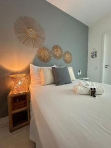 um quarto com uma grande cama branca e uma mesa em POUSADA MAR BELLO em Paripueira
