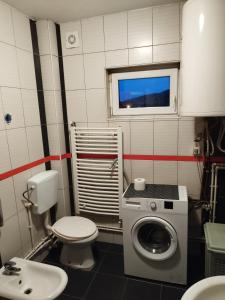 ein Badezimmer mit einer Waschmaschine und einem WC in der Unterkunft Salvatori 