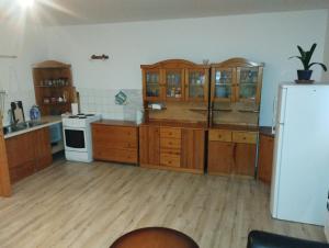 kuchnia z drewnianymi szafkami i białą lodówką w obiekcie Chalupa Mária w Tierchowej