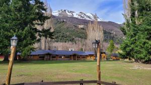 a log cabin with a snow covered mountain in the background at Hostería Villarino in San Martín de los Andes