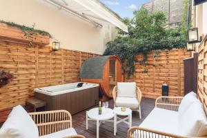 a patio with a hot tub and a table and chairs at Suite luxueuse avec jardin privé Sauna et Jacuzzi in Paris