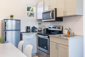 a kitchen with stainless steel appliances and white cabinets at Oasis Jumbo - Complex for Big Groups in Fort Lauderdale